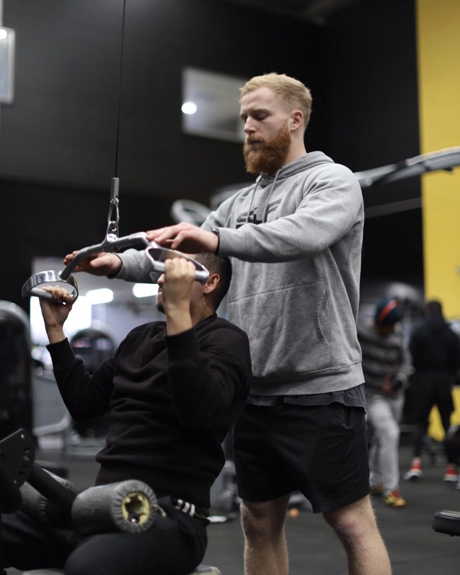 Coaching a client through a lat pulldown in the gym